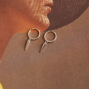 Macro view of silver S925 sterling silver hoop earrings with polished cone spikes