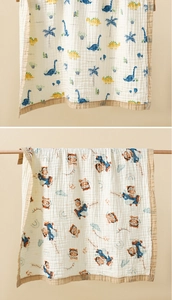 Detail of 6-layer cotton gauze baby towel showing soft texture and cartoon dinosaur patterns