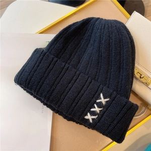 Thick black knitted beanie with white embroidery and cozy ear protection for winter