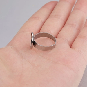 Close-up of adjustable silver stainless steel ring with flat heart-shaped DIY bezel setting