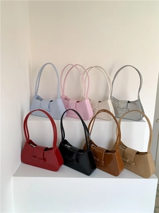 Multiple colors of bow baguette shoulder bags displayed on tiered white stands