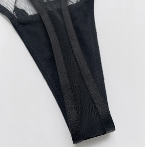 Detailed close-up of the black mesh and leaf embroidery on breathable thin thong