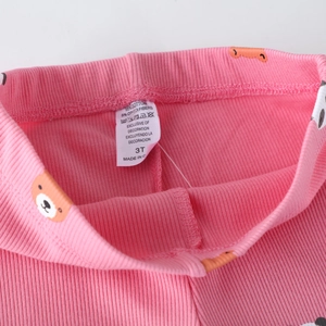 Soft pink ribbed knit girls leggings featuring a bear print and 95% cotton fabric label