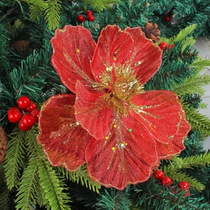 Vibrant red mesh Christmas flower with gold glitter on decorative festive tree branches