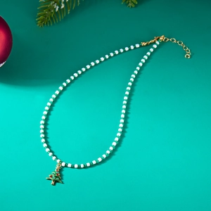 Close-up of handmade beaded Christmas tree necklace with green white beads and gold pendant