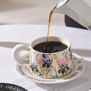 Floral ceramic coffee cup set with saucer and mocha pot pouring coffee in a warm scene