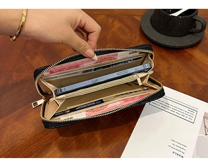 Detailed interior of a long black zip-around wallet with multiple card slots and leather texture