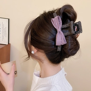 Detail of a purple plaid bow hair claw clip in a stylish half-up hairstyle
