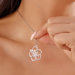 Detail of silver hollow flower pendant necklace with fine curb chain on woman neck