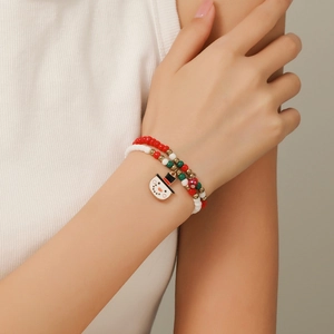 Close-up of a Christmas beaded bracelet with snowman charm on a female wrist