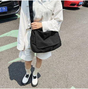 Large black canvas tote bag shown on model for stylish summer commuting and daily wear