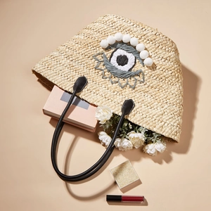 Sac de plage en paille avec motif œil brodé et pompons blancs pour les vacances