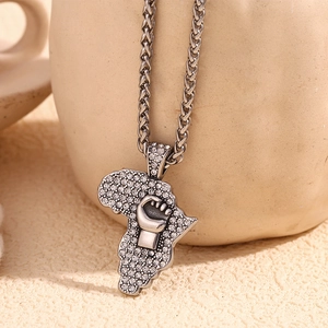 Macro shot of silver Africa map pendant with fist pattern and inlaid crystals