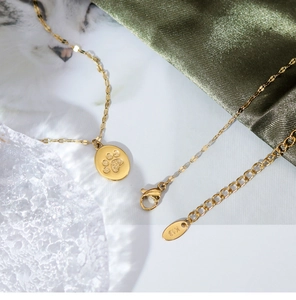 Macro detail of gold cat paw pendant with K18 hallmark on adjustable lobster clasp chain