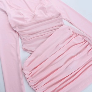 Detalle de vestido rosa de manga larga con retazos de malla y textura de tela plisada