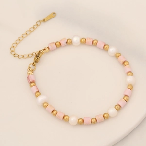 Macro detail of pink marble beads, white pearls and gold stainless steel clasp