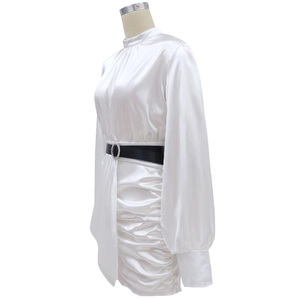Détail de la robe en satin blanc avec manches lanternes et ceinture noire à la taille