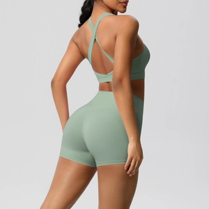 Detail von Cross-Back Yoga-BH und hoch taillierten salbeigrünen Gym-Shorts am Model