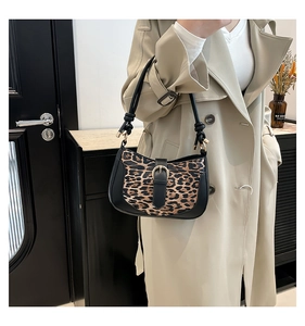 Detail of leopard print crescent bag with black leather trim and golden buckle
