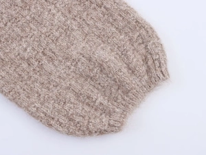 Close-up detail of soft oatmeal chunky knit wool texture with fuzzy fiber details