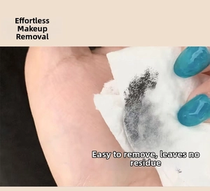 Macro shot of makeup remover wiping off long-lasting black mascara from the skin
