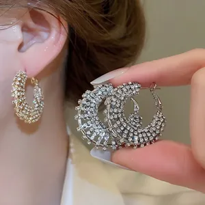 Elegant silver circle hoop earrings featuring multi-row crystal pavé on warm background
