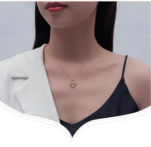 Close-up of a gold S925 silver MOM heart necklace with a sparkling zircon stone