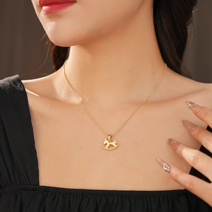 Gros plan d'un collier avec pendentif cheval doré et chaîne à billes sur un mannequin