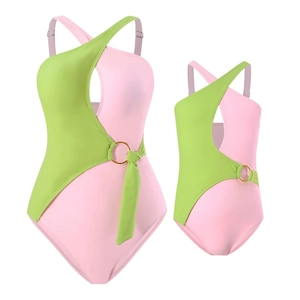 Pink and green color block one-piece swimsuit with golden ring detail and cutouts