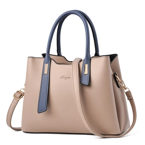 Elegant beige PU leather handbag with blue handles and adjustable strap on white background