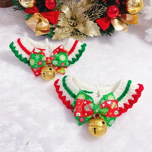 Detail of hand-knitted Christmas pet collars with festive bows and golden bells