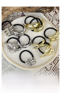 Detailed view of assorted geometric metal hair ties in polished gold and silver finishes