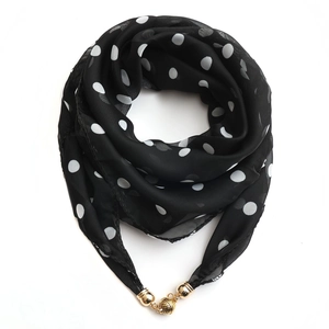 Detail of black polka dot chiffon scarf necklace with gold magnetic beads on white background