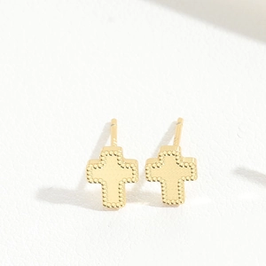 Detail of gold cross stud earrings featuring an S925 silver hallmark on white texture