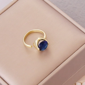 Detailed macro view of an adjustable gold ring with a faceted navy blue zircon stone
