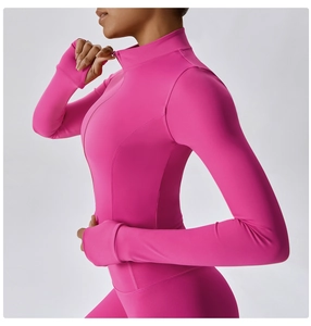 Détail de la veste de course rose avec fermeture éclair, passe-pouces et coupe ajustée