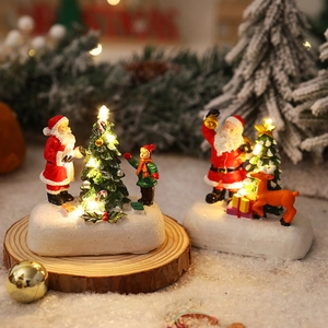 Detailed view of LED lighted resin Christmas house scene with Santa and reindeer on snow