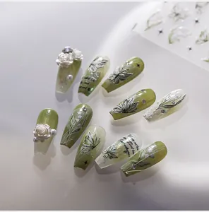 Detail view of 3D embossed press-on nails with 3D roses and butterfly floral designs