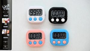 Digital timer set with LCD screen shown magnetically attached to a refrigerator door