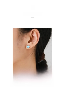 Detail of s925 silver heart opal stud earring worn on model for a minimalist look