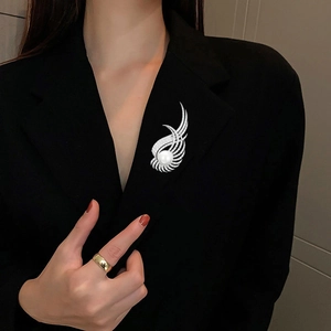 Broche ailes en argent avec zircons et perle blanche sur revers de veste noire