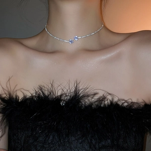 Detail of double-layer silver choker featuring zircon star pendants on collarbone