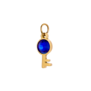 Detail of a golden key pendant featuring a round blue gemstone inlay on top