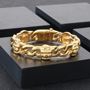 Macro detail of gold 316L stainless steel Cuban link bracelet with skull engravings