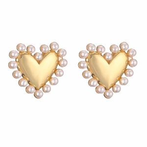 Vue détaillée de boucles d'oreilles cœur dorées serties de perles d'imitation