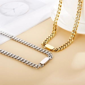 Ensemble collier et bracelet à maillons cubains dorés et argentés sur fond neutre chic