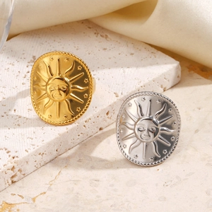 Vintage sun relief stainless steel rings in gold and silver on a textured stone base