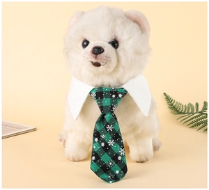 Detail of green plaid pet necktie with snowflake prints on white collar for dogs and cats
