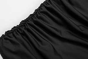 Detail of ruched black knit fabric with premium texture and precise stitching on the dress