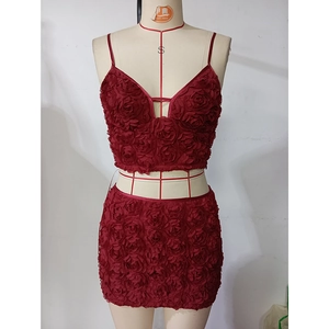 Detailaufnahme des dunkelroten Crop-Tops mit 3D-Blumenstruktur und schmalen Trägern